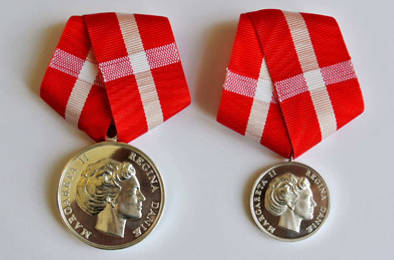 Fortjenstmedaljen (til venstre) og Den Kongelige Belønningsmedalje (til højre).